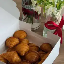 علبة كرواسون بجانب باقة ورد